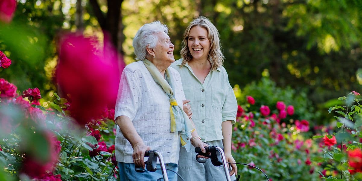 senior woman and daughter walking through the garden