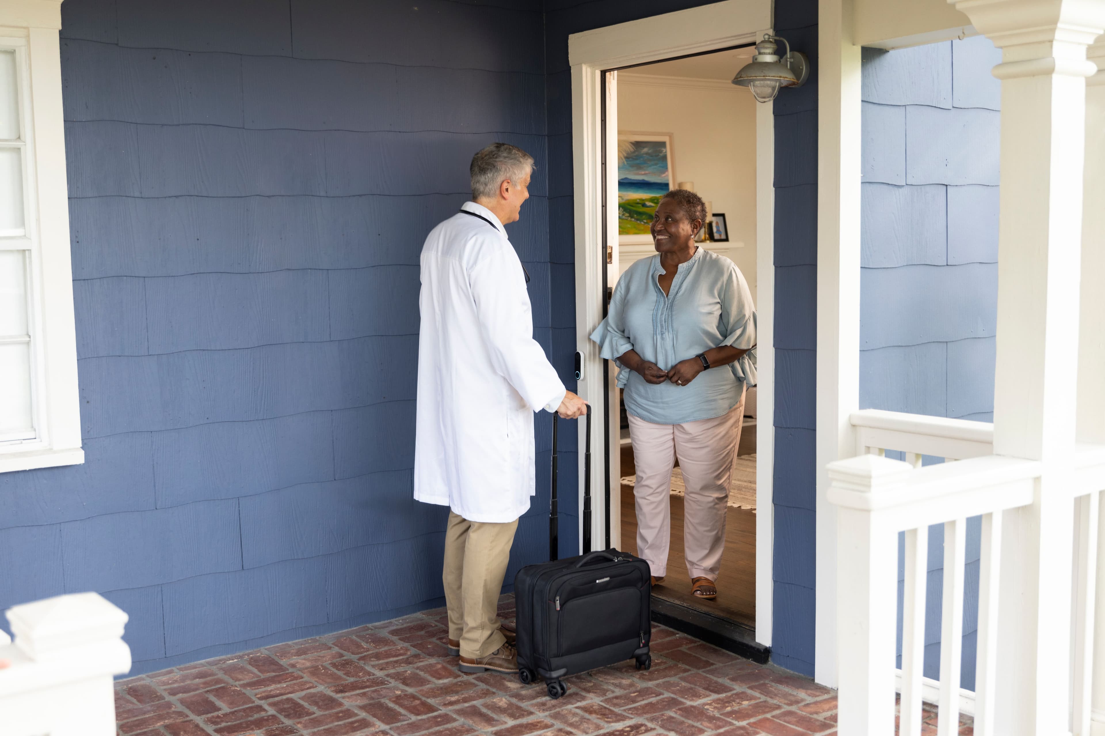 Black woman at front door with male Doctor