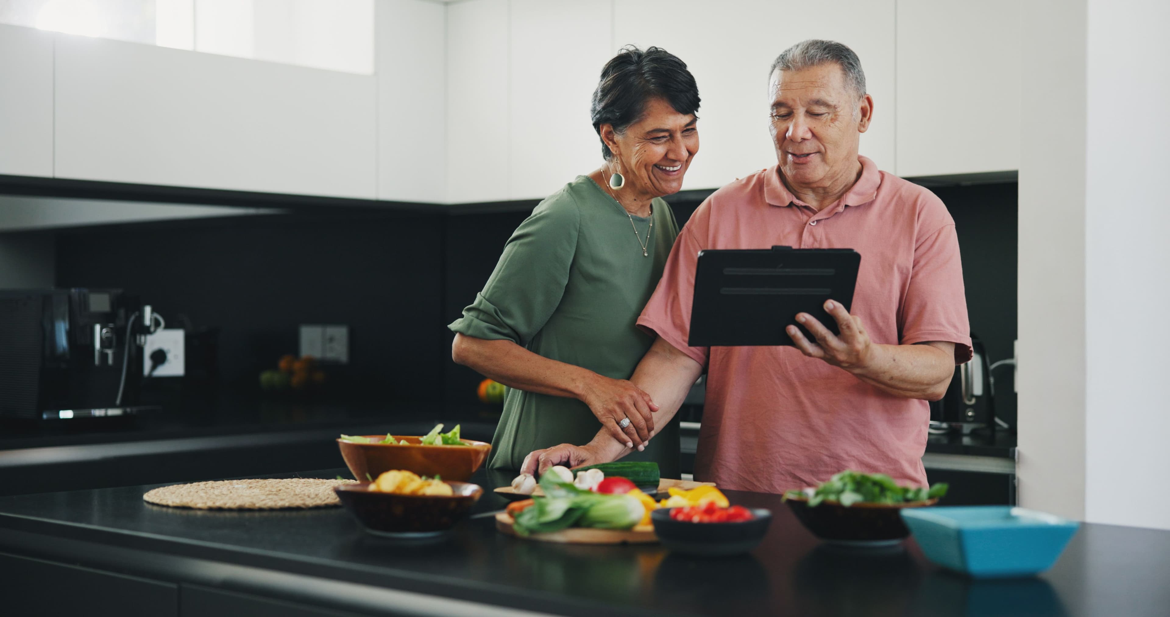 Senior couple, tablet and recipe for meal, kitchen and cooking together for bonding, smile and support. Happy elderly people, healthy food and diet in retirement, fun and app for meal prep or web.