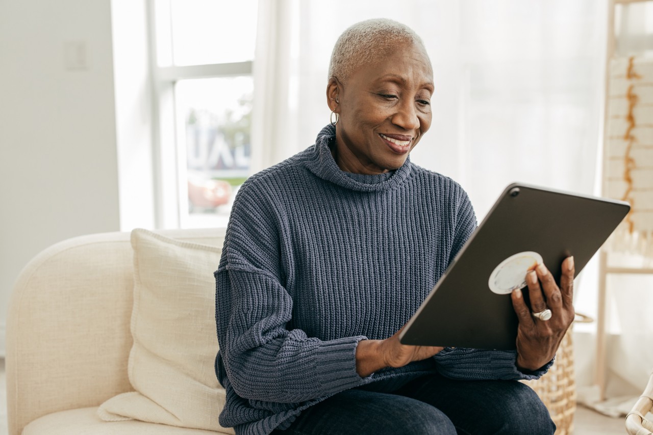 Senior women using tablet for online banking at home